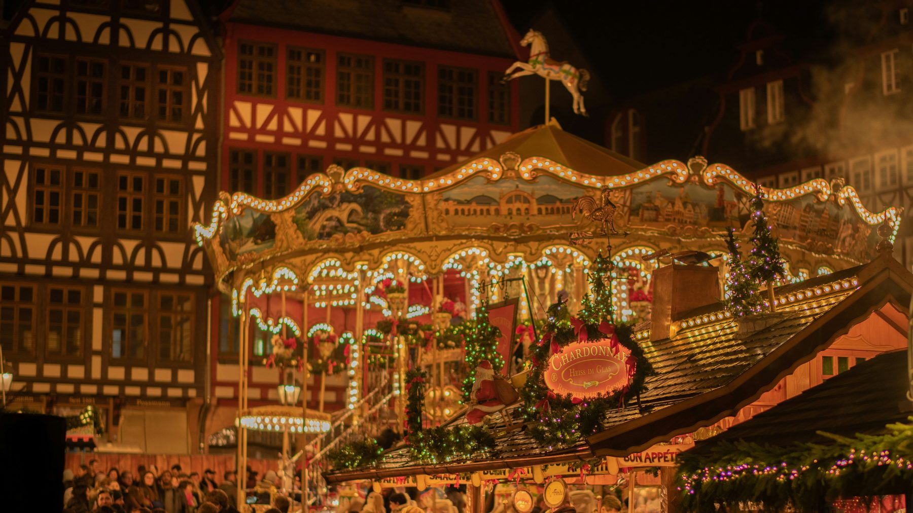 A lit carousel at a German Christmas market at night