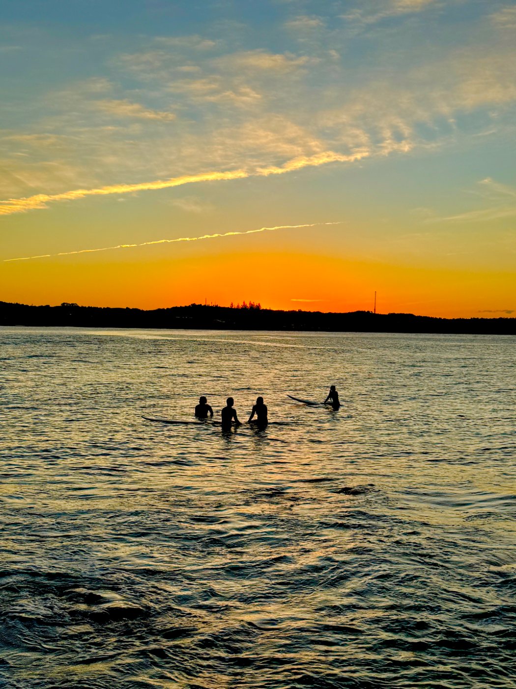 Surfers waiting out at sunset