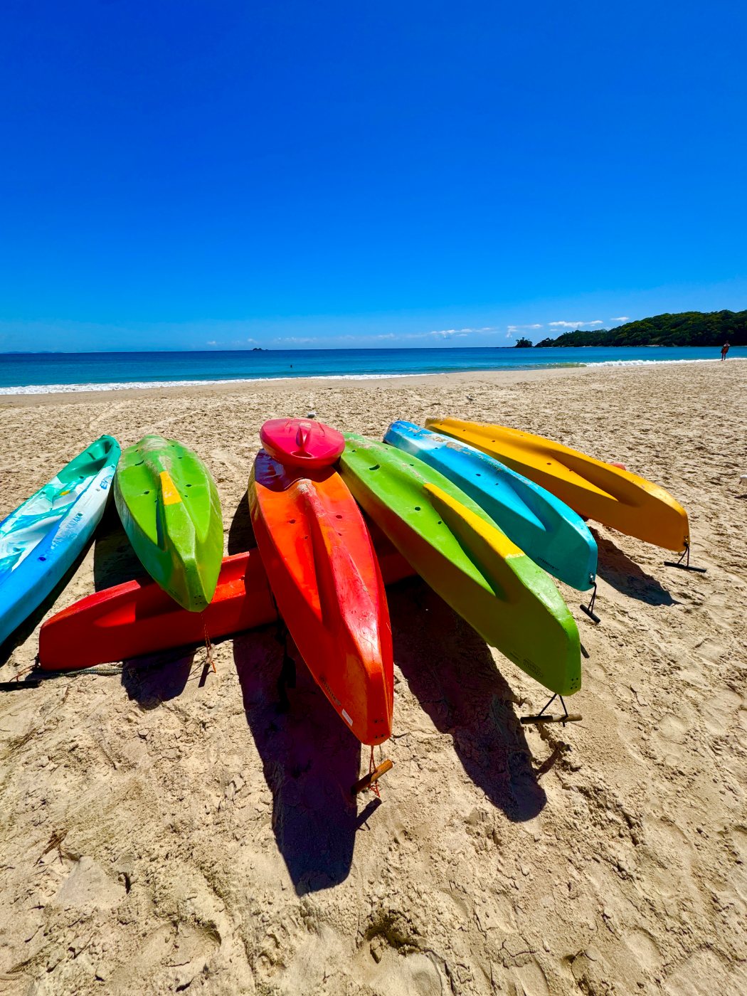 Kayaks stacked on the sand